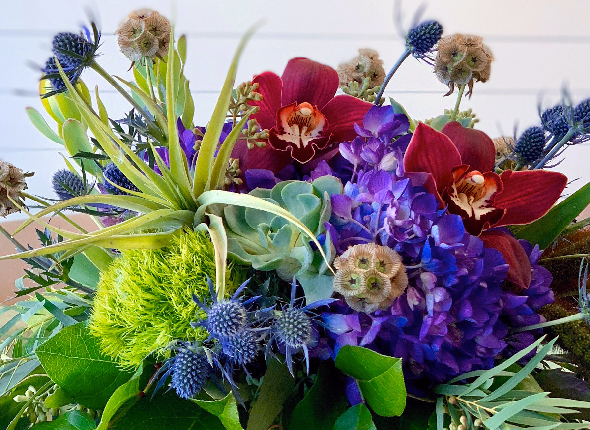 A lovely green, purple and maroon arrangement